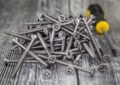 Vis et tournevis sur bois, assemblage de bricolage, matériel de construction