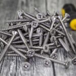 Vis et tournevis sur bois, assemblage de bricolage, matériel de construction