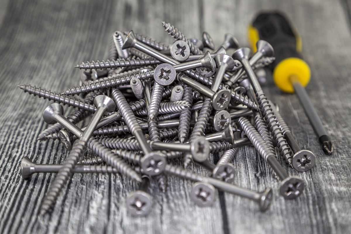 Vis et tournevis sur bois, assemblage de bricolage, matériel de construction