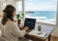 Bureau lumineux face à l'océan à biarritz, ordinateur portable affichant des courbes de trafic, carnet de notes, ambianc