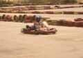 Un pilote en kart rouge conduit sur une piste de karting